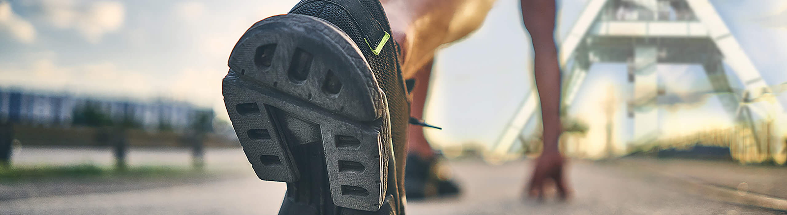 Orthopädie Dr. Knaup Bochum - Läufer in Startstellung mit Sportschuh vor Förderturm